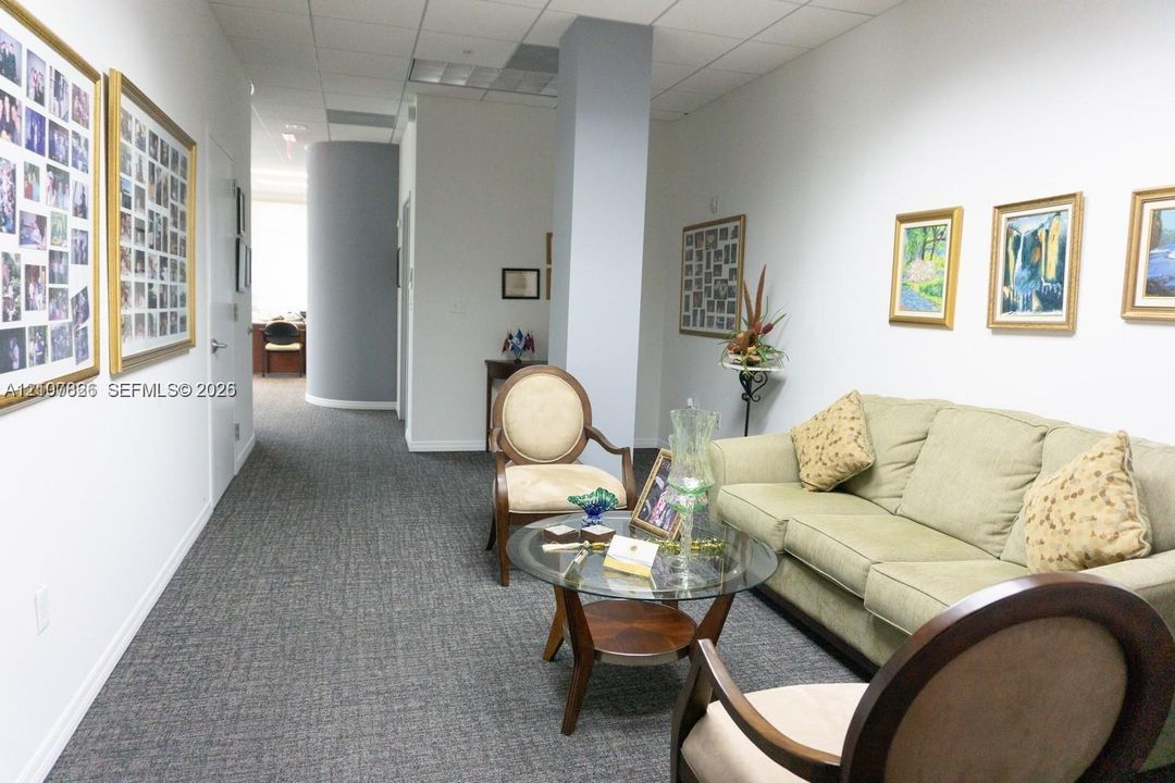 Interior space featuring a curved architectural wall, grey patterned carpeting, and a central structural column