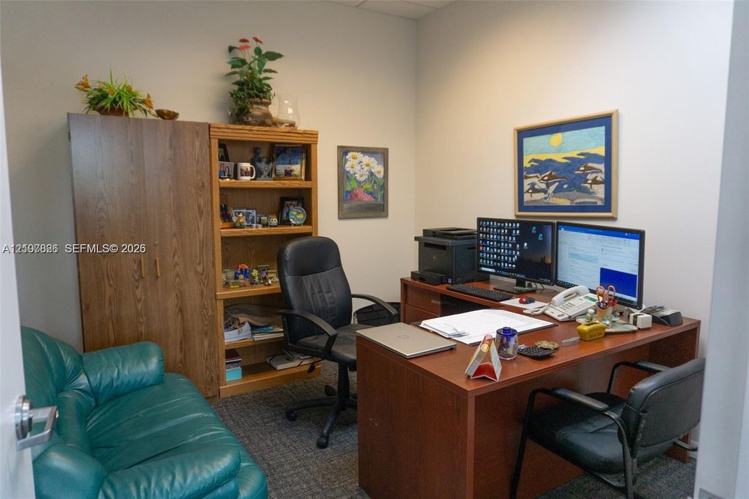 Room featuring built-in wood-finish cabinetry, integrated shelving, and carpeted flooring