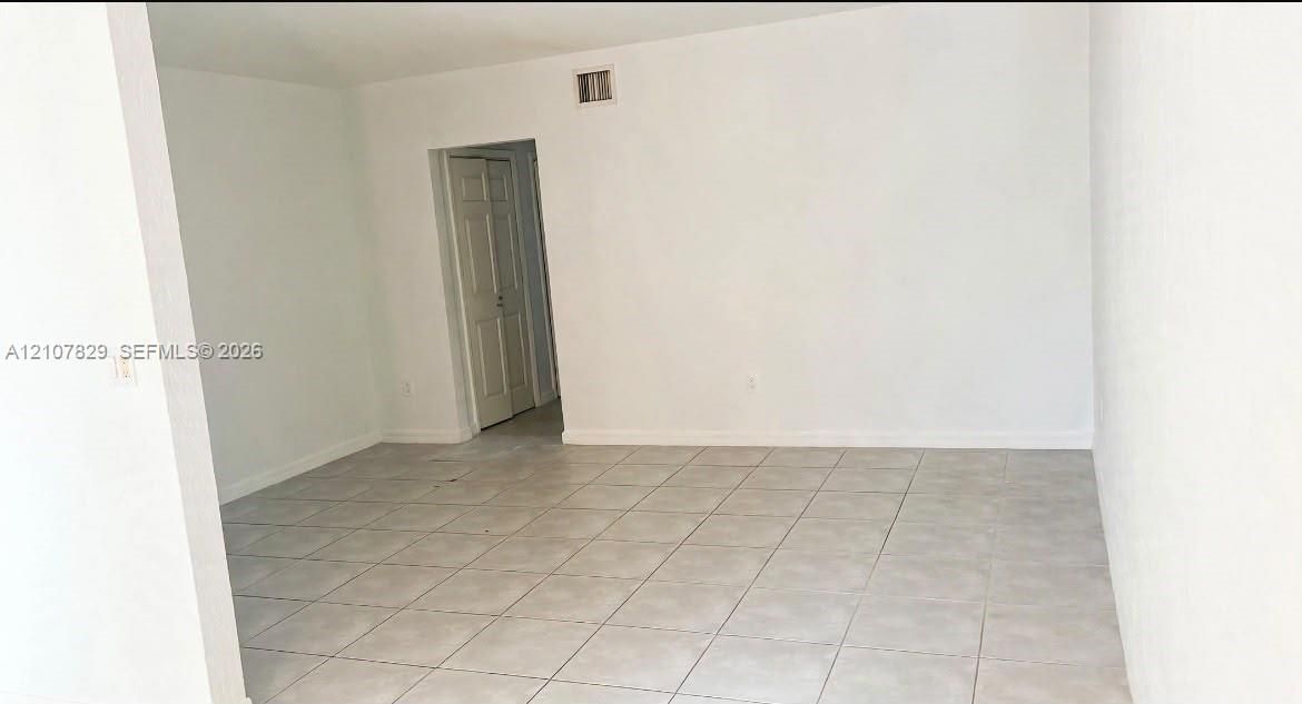 Interior space featuring neutral wall tones, large-format ceramic tile flooring, and multi-panel swinging doors