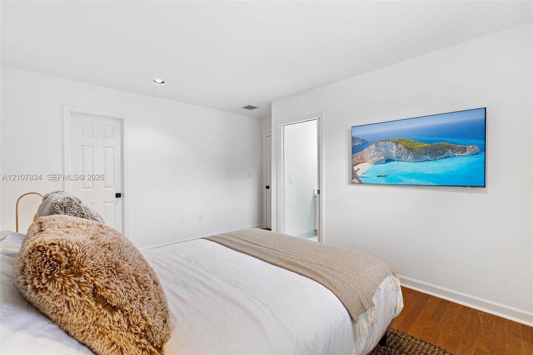 Neutral-toned interior featuring wood-finish flooring, recessed lighting, and white six-panel interior doors