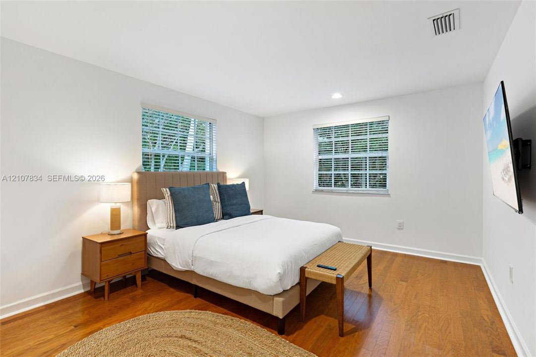 Neutral-toned interior walls, wood-finish flooring, and dual windows with horizontal blinds
