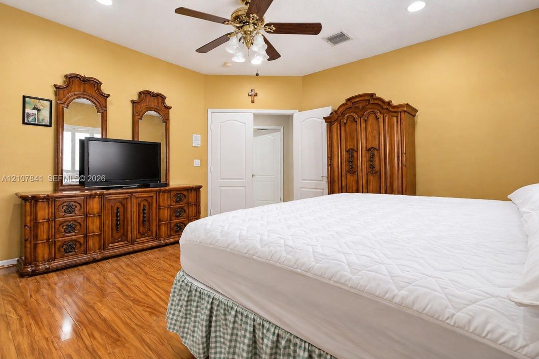 Wood-finish flooring, recessed lighting, and a multi-light ceiling fan