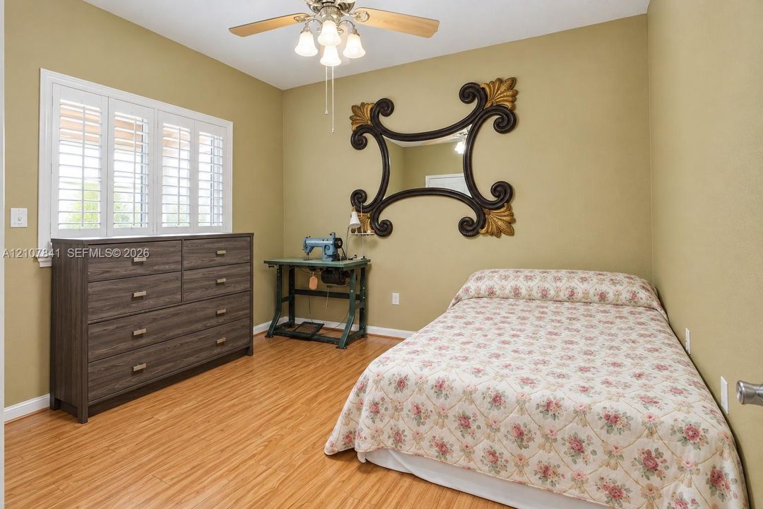 Wood-finish flooring, plantation shutters, and a multi-light ceiling fan