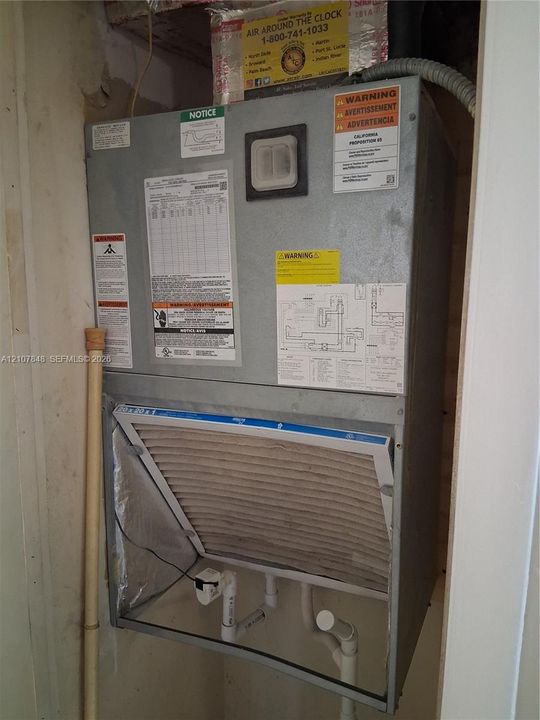 Wall-mounted air handling unit featuring a replaceable pleated air filter and integrated drainage piping