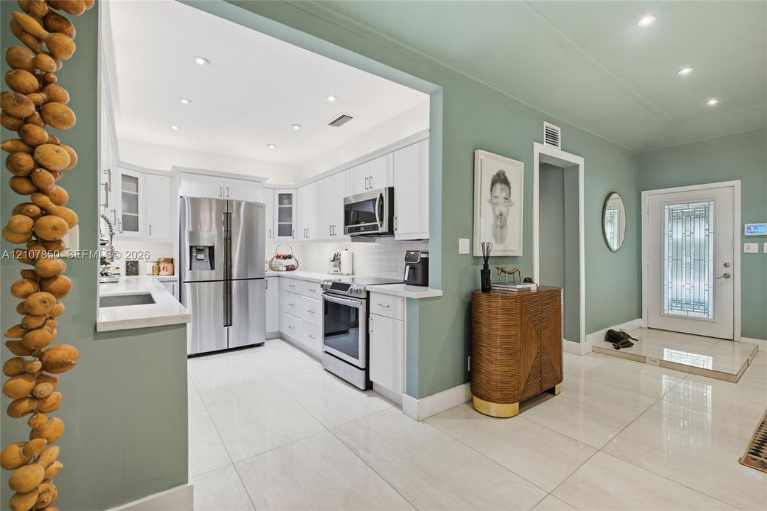 Kitchen featuring white shaker-style cabinetry, stainless steel appliances, recessed lighting, and tile flooring throughout