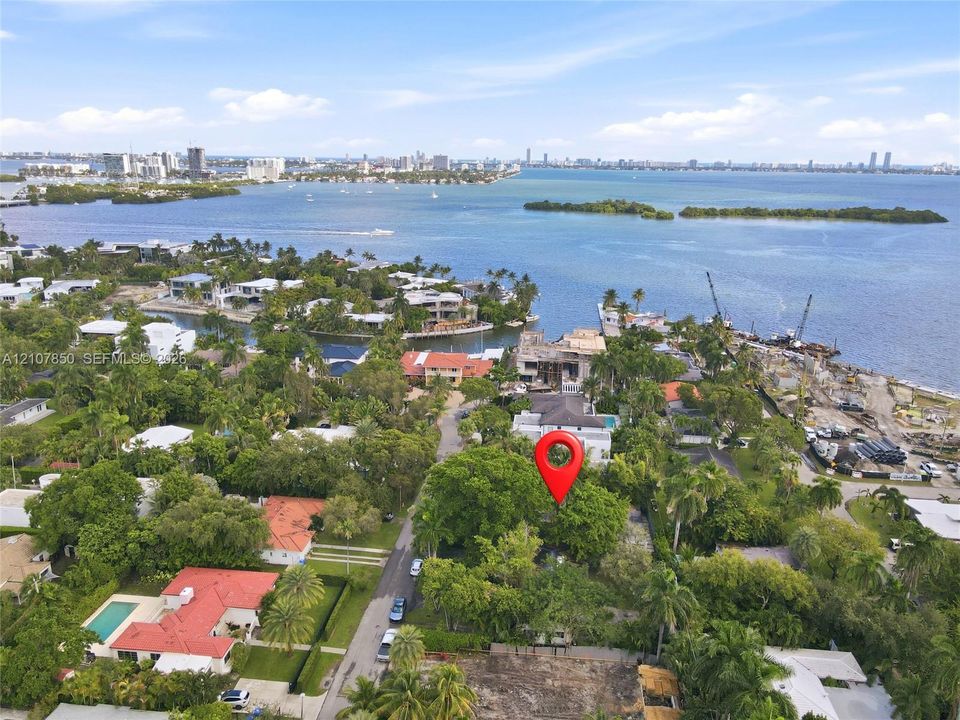 Aerial perspective of a coastal parcel featuring mature canopy trees, waterfront proximity, and established neighborhood foliage