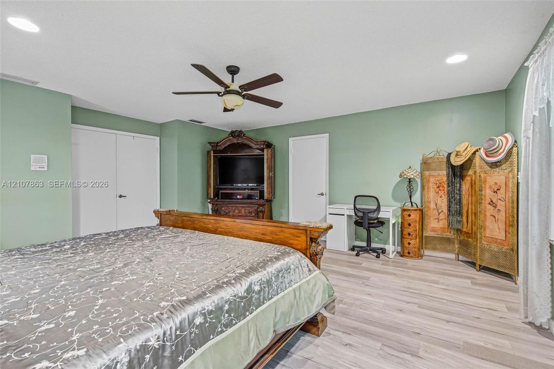 Spacious room featuring wood-finish flooring, recessed lighting, and a ceiling fan
