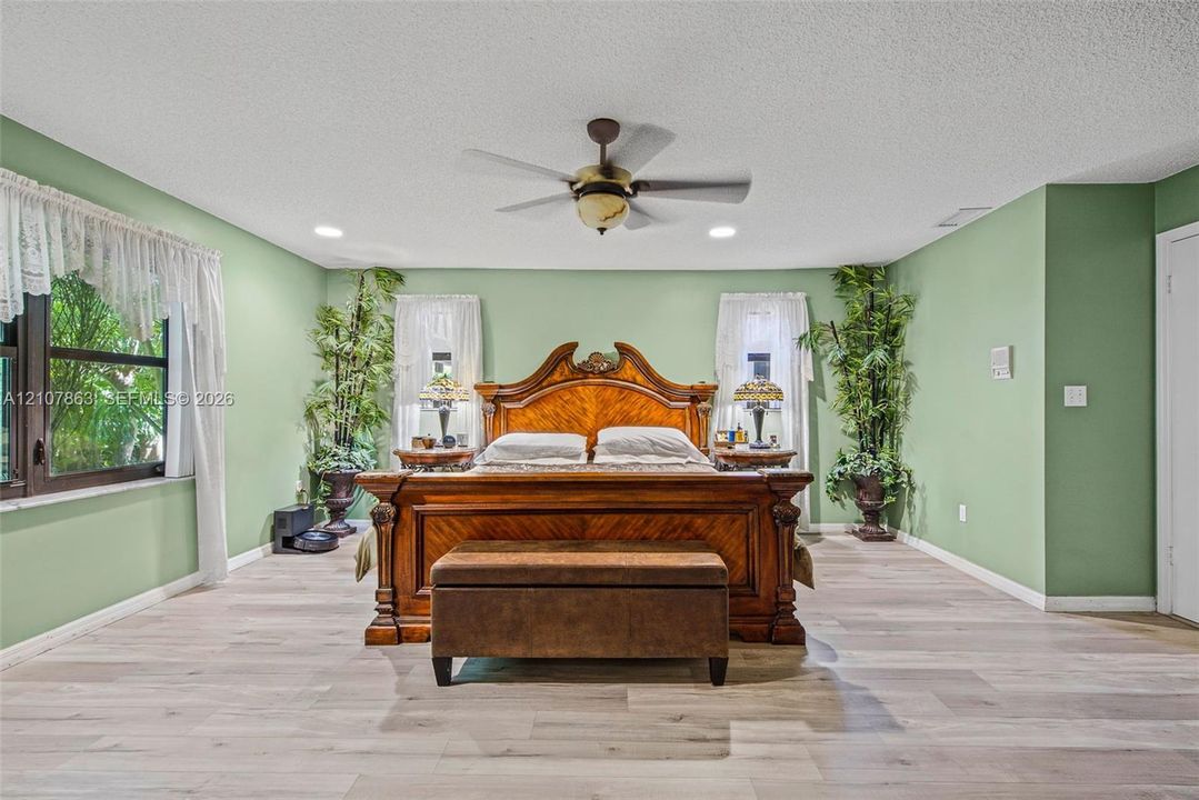 Room with wood-finish flooring, recessed lighting, and a ceiling-mounted fan with integrated light fixture
