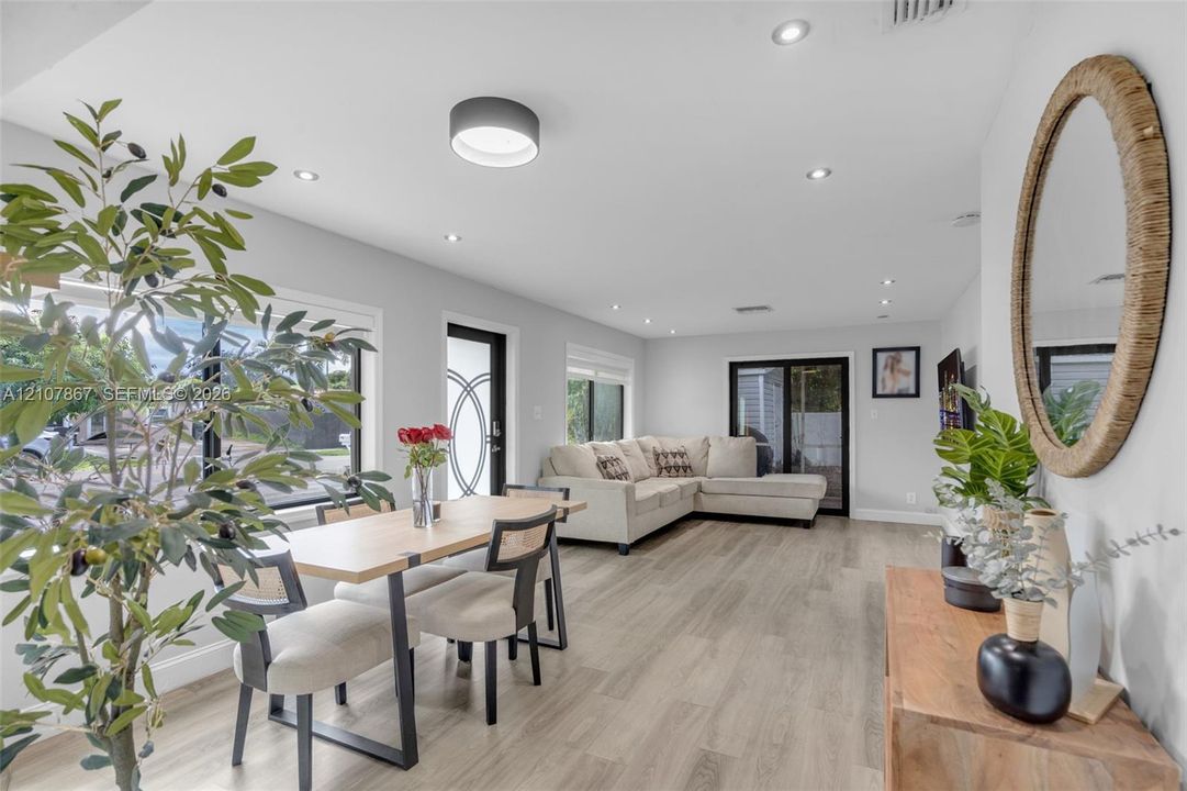 Open-concept room featuring wood-finish flooring, recessed lighting, and a glass-paneled entry door