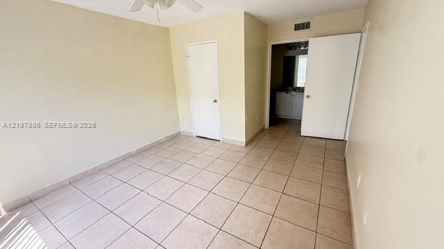 Interior room featuring neutral wall paint, tile flooring, and a ceiling fan