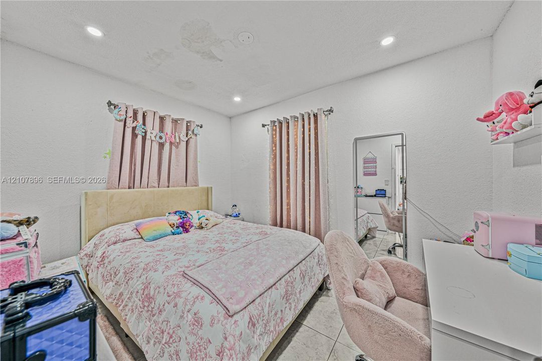 Bedroom featuring tile flooring, recessed lighting, and two windows
