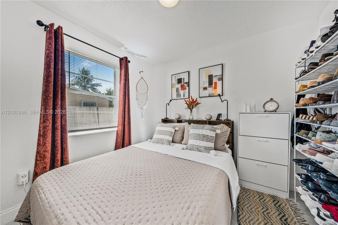 Bedroom featuring a horizontal window and installed white metal shelving