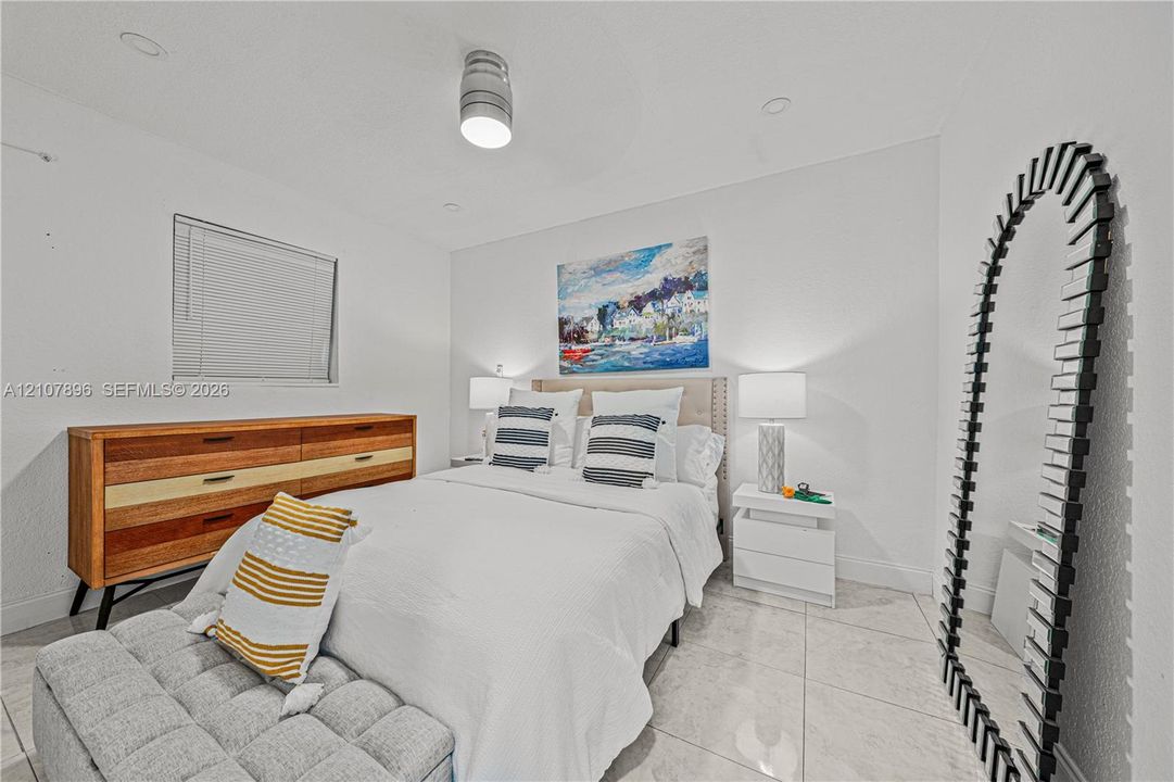 Neutral-toned interior featuring large-format tile flooring, recessed ceiling lighting, and a minimalist flush-mount fixture