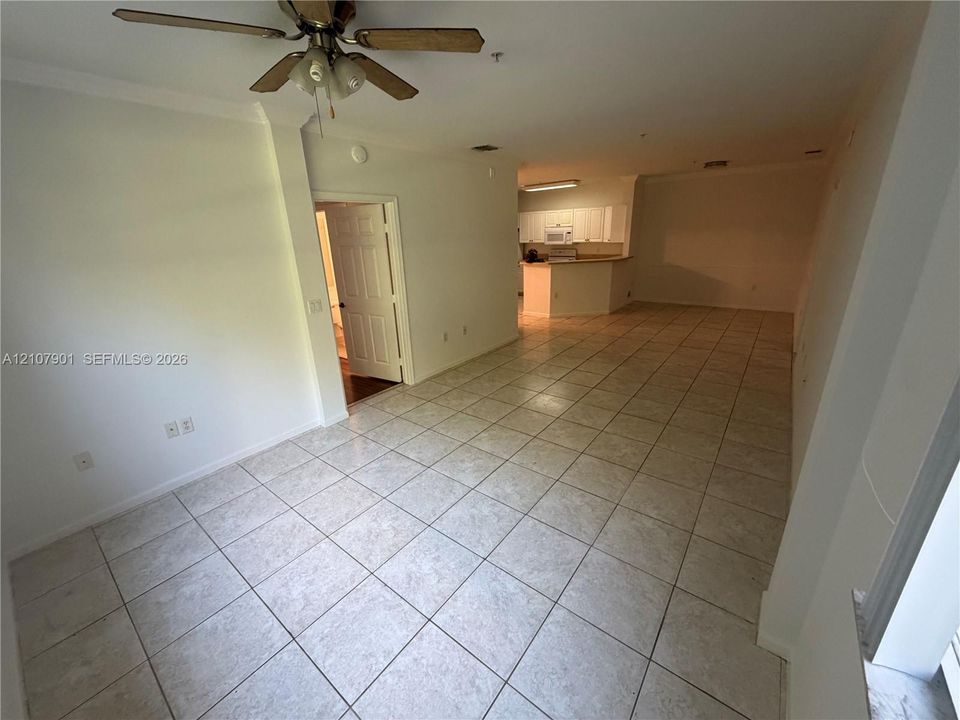 Ceramic tile flooring, ceiling fan with integrated lighting, and built-in kitchen cabinetry with peninsula