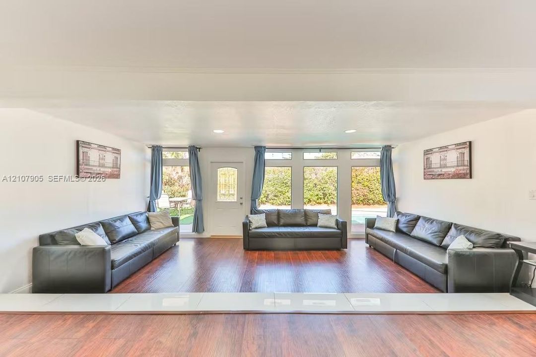 Sunken living area featuring wood-finish flooring, recessed lighting, and multiple paneled glass windows