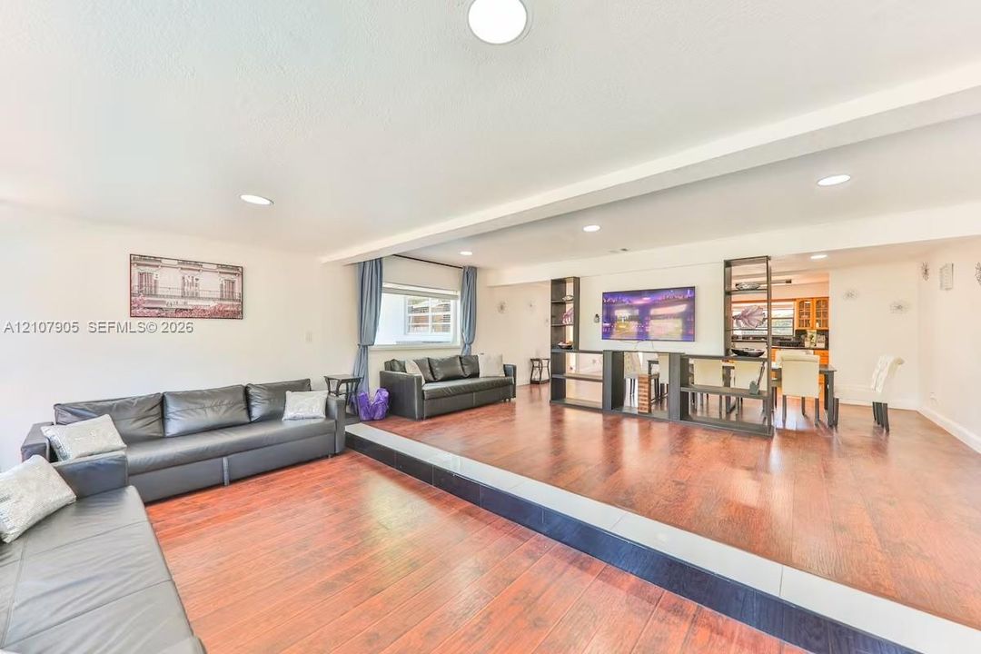 Sunken living area featuring wood-finish flooring, recessed lighting, and a stepped platform divider