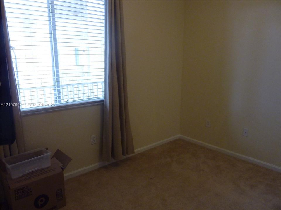 Sliding glass door with horizontal blinds and neutral-toned wall-to-wall carpeting