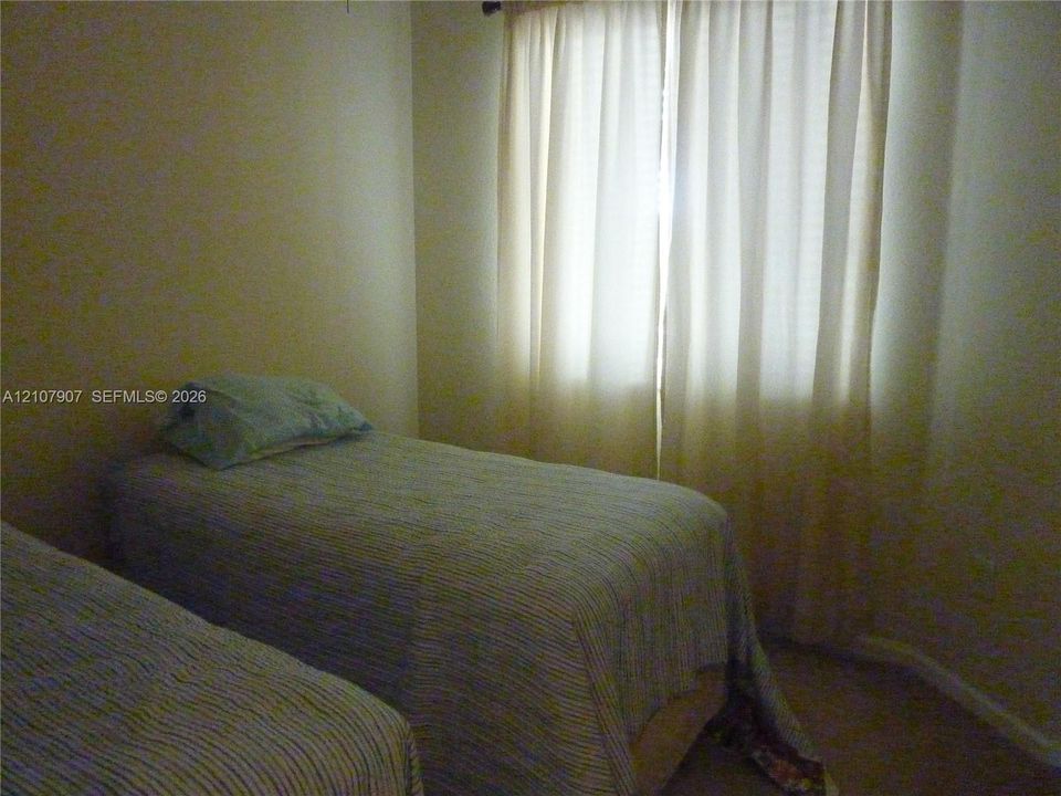 Neutral-toned interior room featuring wall-to-wall carpeting and a large window