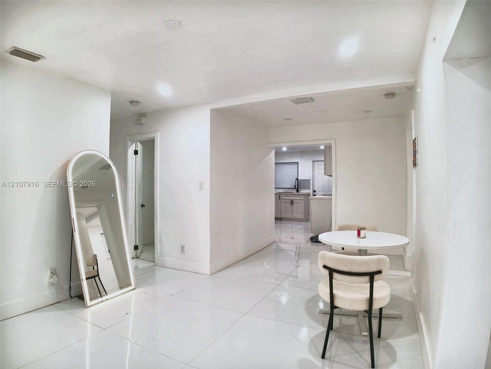 Large-format neutral tile flooring throughout with recessed ceiling lighting