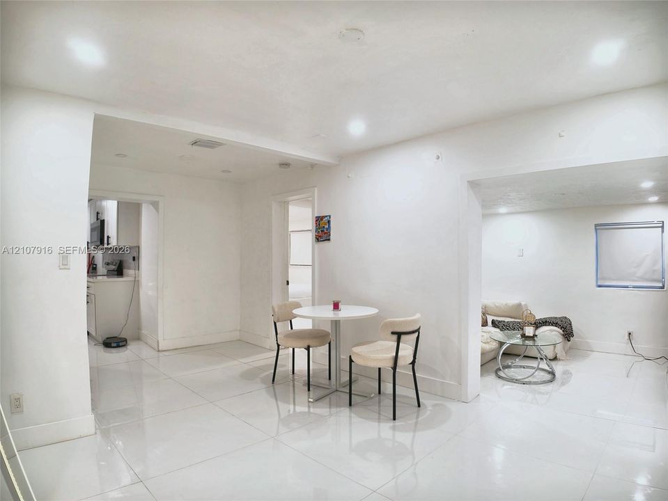 Large-format white tile flooring, recessed ceiling lighting, and crisp neutral wall finishes