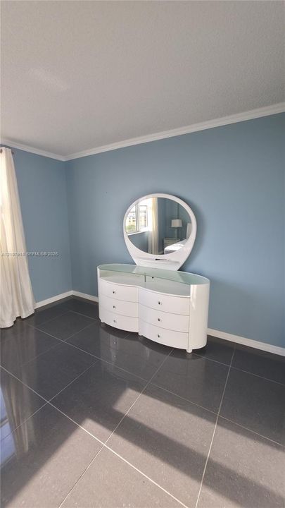 Interior space featuring dark-toned tile flooring and painted walls