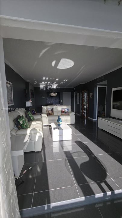 Open-concept living space featuring large-format dark floor tiles and deep-toned wall finishes