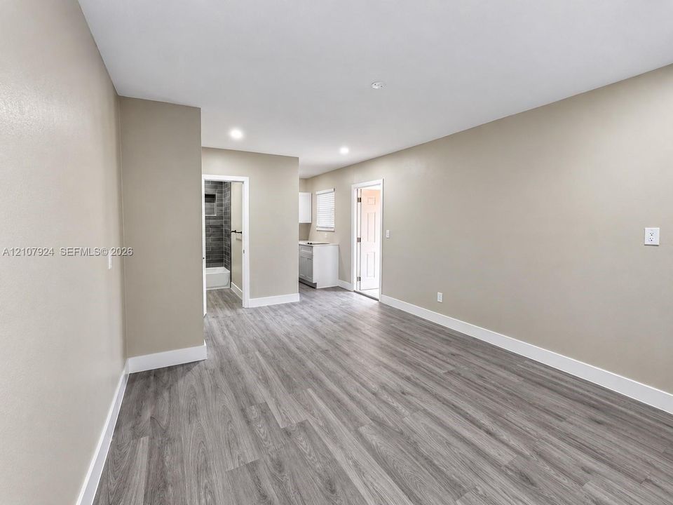 Neutral-toned interior featuring wood-finish flooring, recessed lighting, and smooth-finish walls