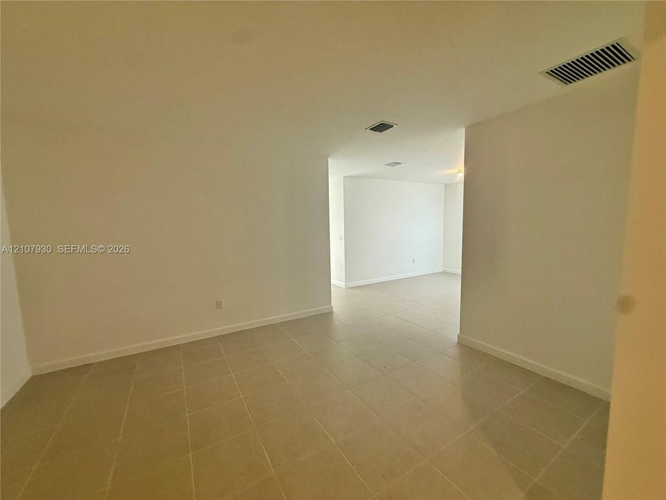 Neutral-toned ceramic tile flooring throughout the interior, complemented by smooth walls and high ceilings