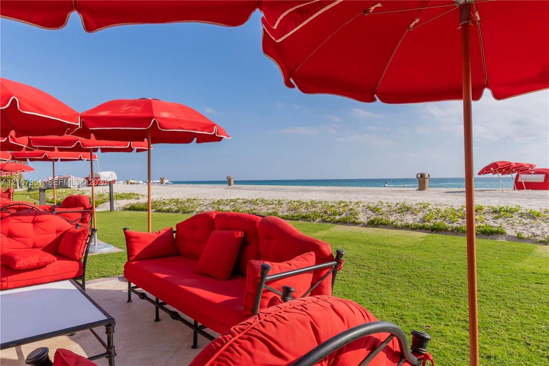 Manicured lawn bordered by a sand shoreline and oceanfront horizon