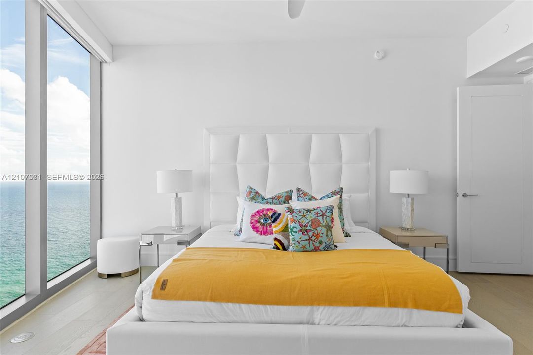 Floor-to-ceiling windows, wood-finish flooring, and white interior finishes