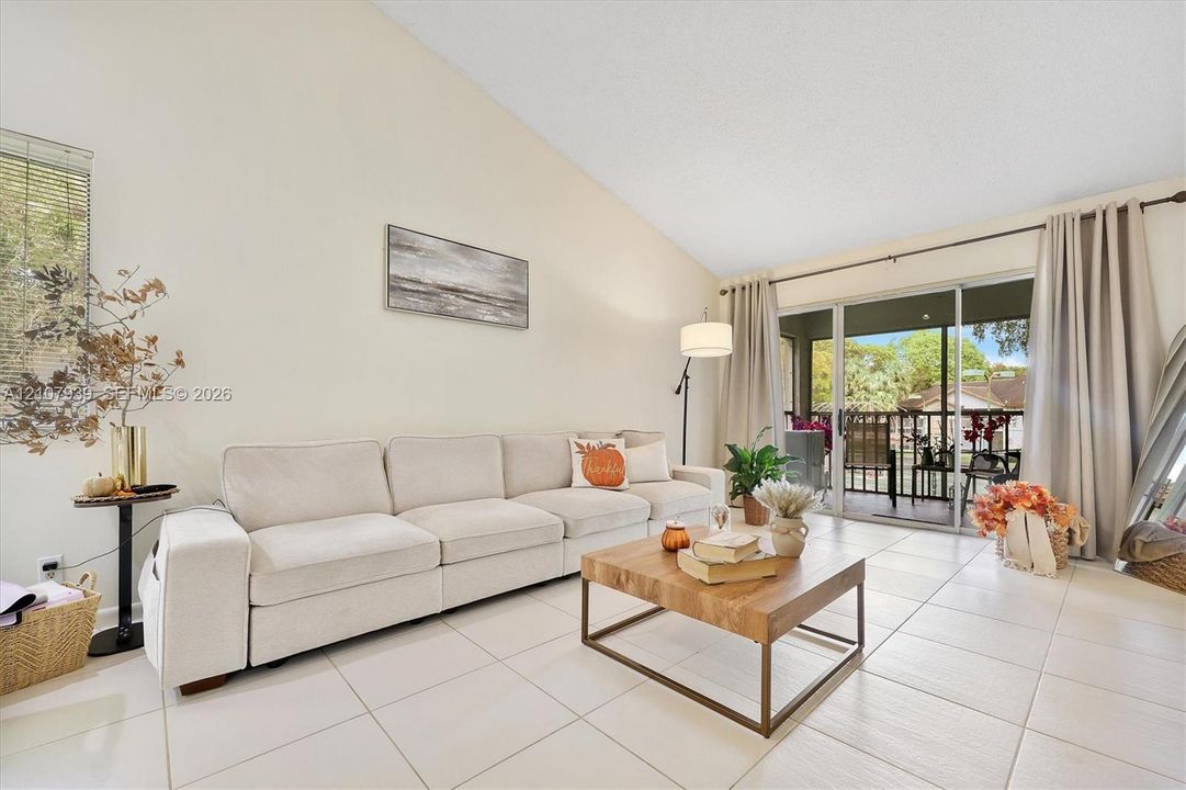 Vaulted ceilings, large-format tile flooring, and glass sliding doors providing external access