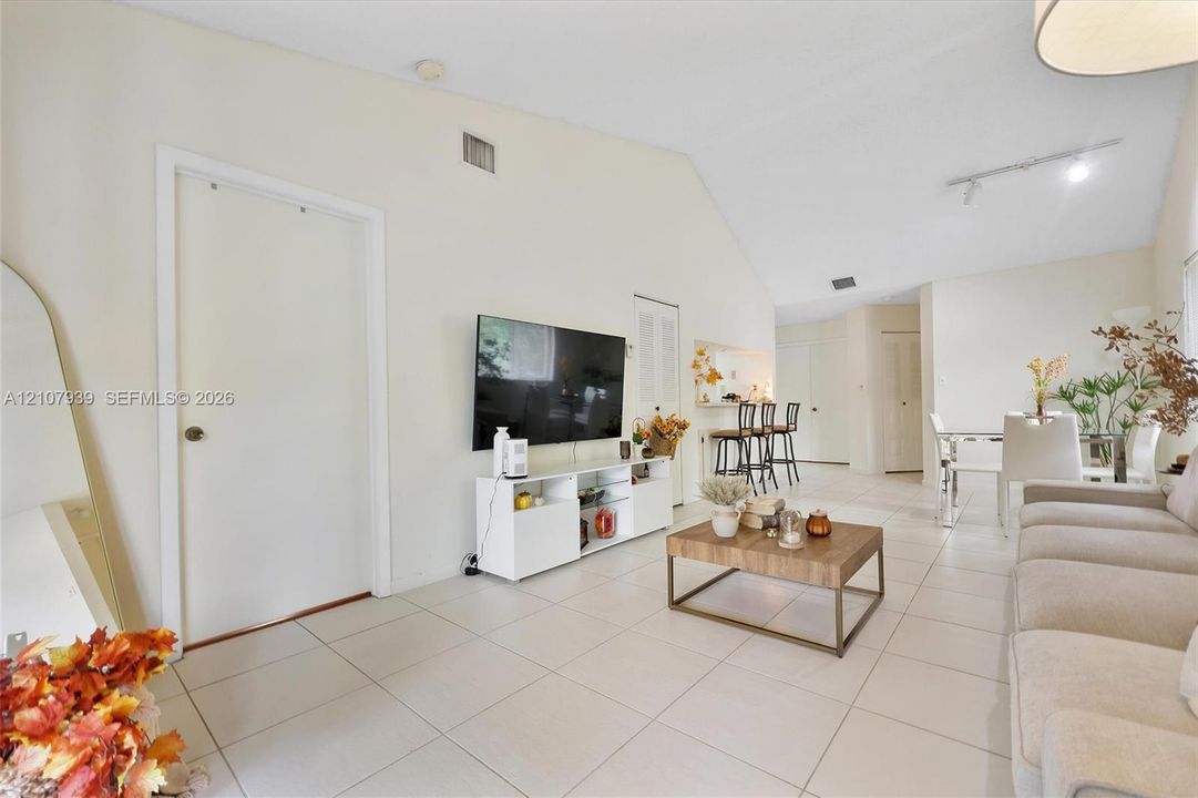 Vaulted ceilings, large-format tile flooring, and adjustable track lighting