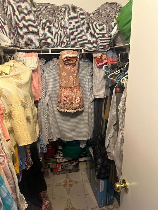 Storage closet featuring wire shelving and tiled flooring