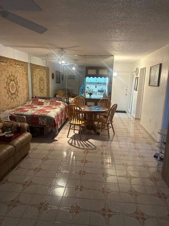 Ceramic tile flooring with decorative inlay, full-wall mirrored paneling, and ceiling-mounted fans
