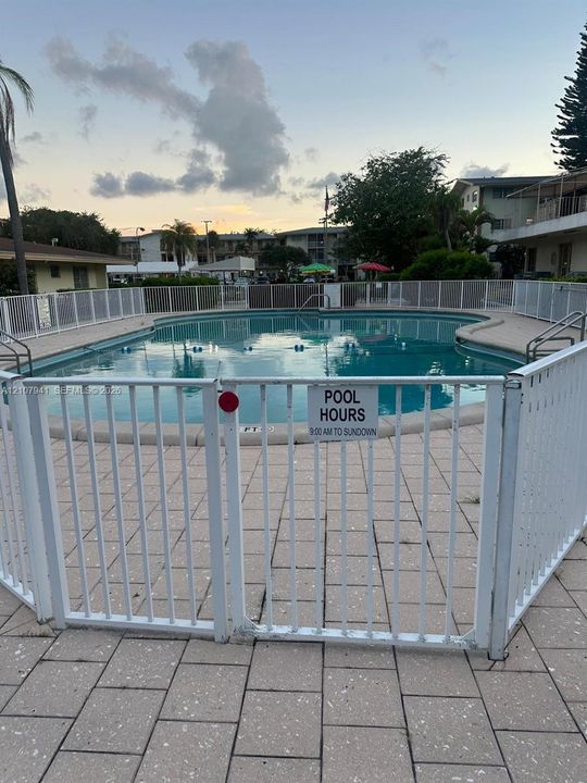 In-ground swimming pool with a perimeter fence and concrete paver decking