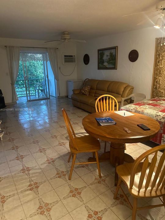 Ceramic tile flooring with decorative inlay, sliding glass door, and ceiling fan