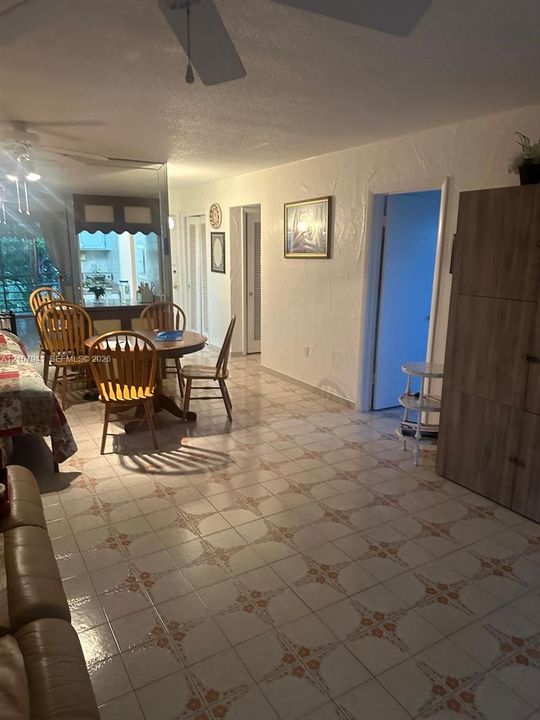 Interior space featuring patterned ceramic tile flooring, textured wall finishes, and ceiling-mounted fans