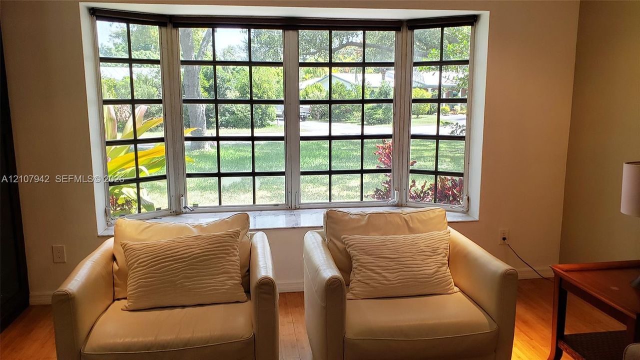Multi-pane bay window featuring a stone sill and wood-finish flooring
