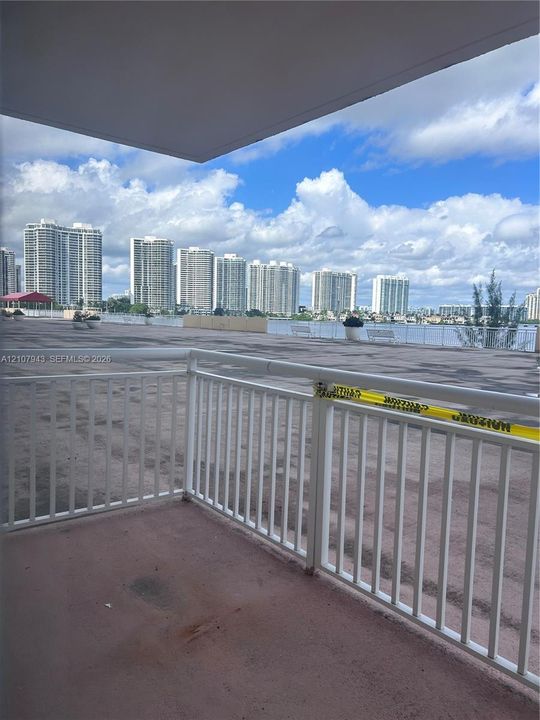 Covered balcony featuring white metal railings and expansive outdoor space