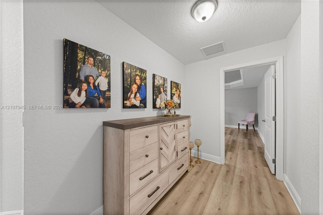 Interior space featuring wood-finish flooring, neutral wall tones, and a flush-mount ceiling light fixture