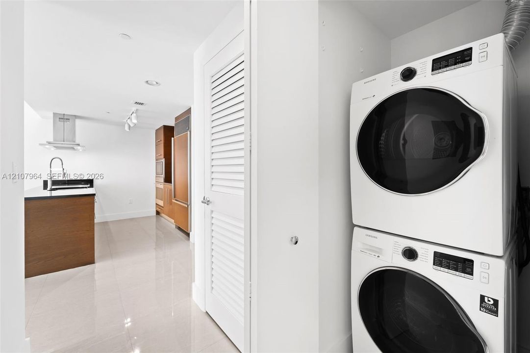 Stacked laundry unit featuring white front-load appliances