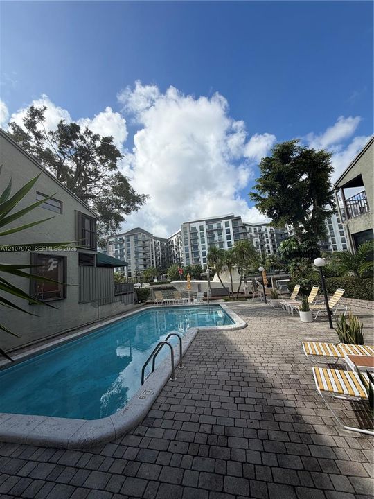 Swimming pool with integrated metal handrails and a surrounding paver stone deck