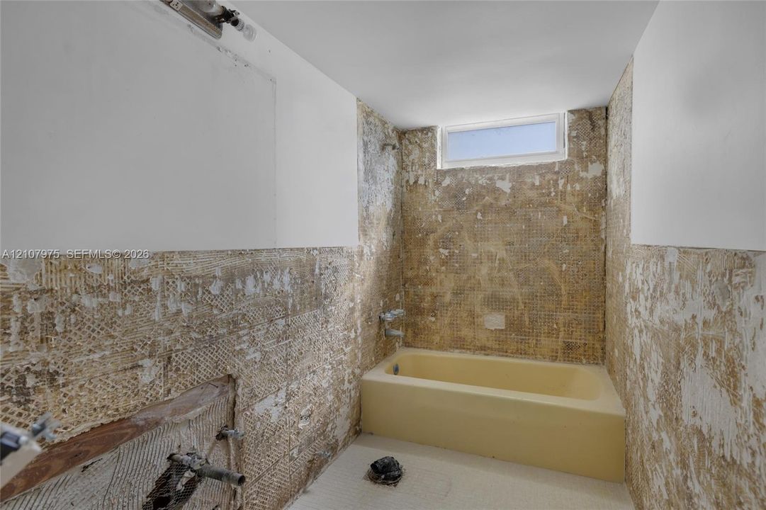 Bathroom featuring an alcove bathtub with chrome fixtures and a transom window