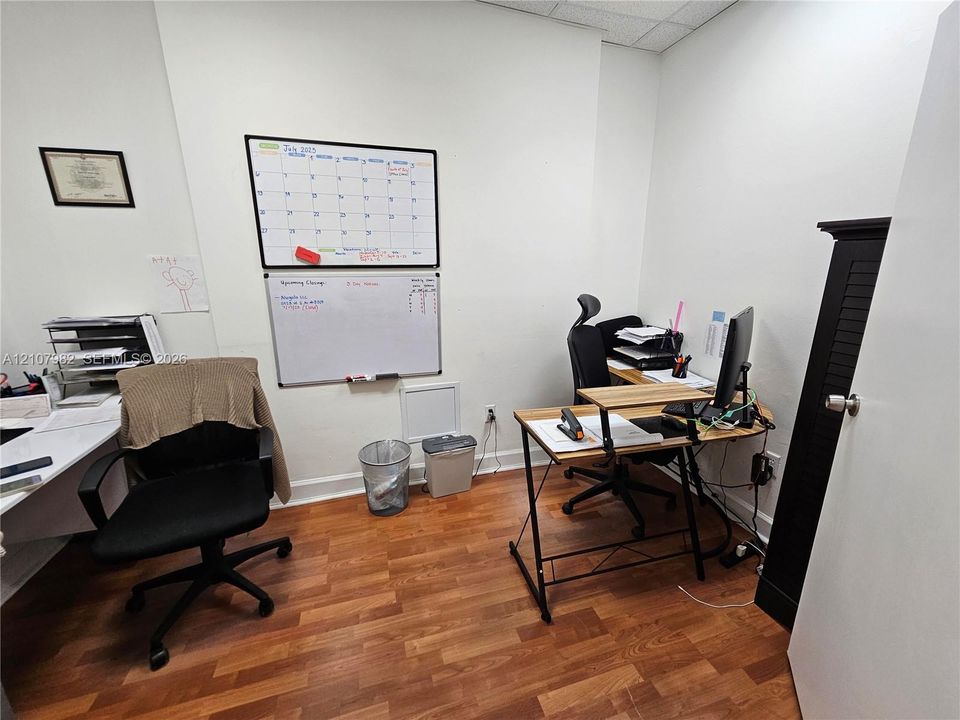Room featuring wood-finish flooring, white walls, and a recessed ceiling panel