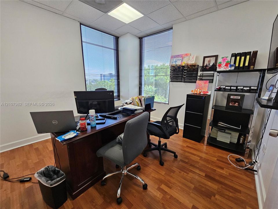 Corner office featuring wood-finish flooring, floor-to-ceiling windows, and recessed lighting