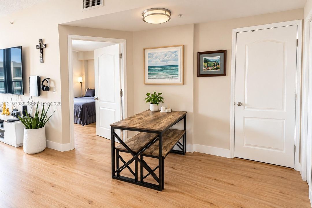 Wood-finish flooring, neutral wall tones, arched-panel interior doors, and flush-mount ceiling lighting