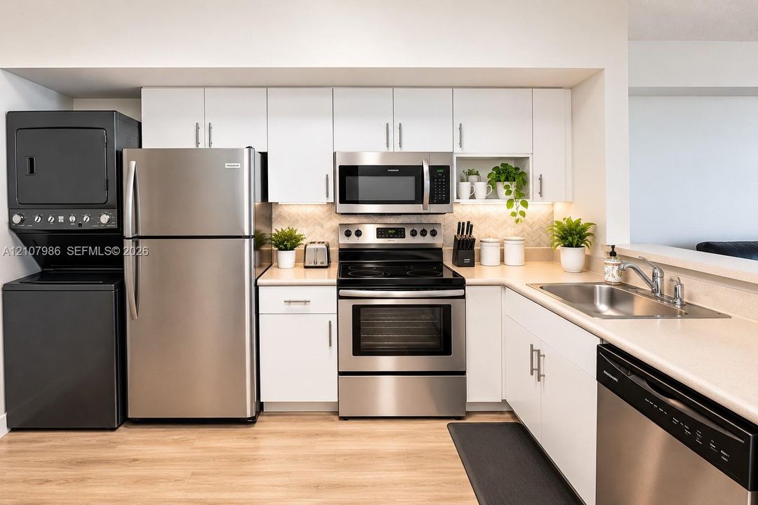 Kitchen featuring white shaker-style cabinetry, stainless steel appliance suite, herringbone tile backsplash, and wood-finish flooring