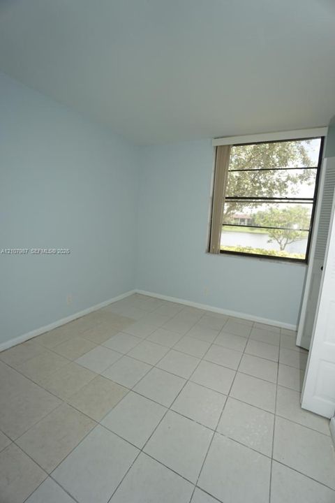 Neutral-toned tile flooring, light-colored walls, and a window with exterior water feature exposure