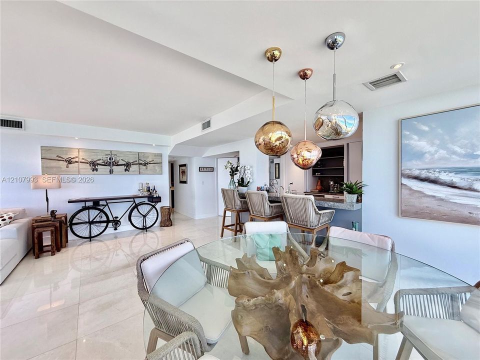 Polished tile flooring, built-in wet bar with stone countertop, and decorative metallic globe pendant lighting