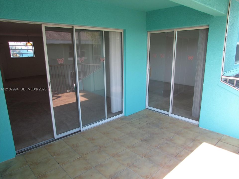 Covered balcony featuring ceramic tile flooring and two sets of sliding glass doors